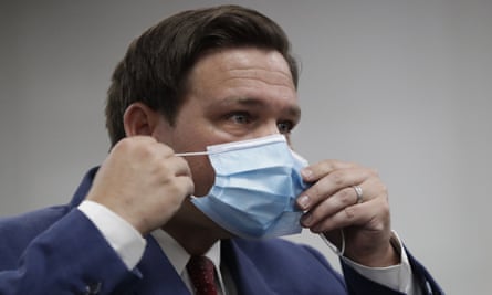 Florida’s governor, Ron DeSantis, puts on his mask as he leaves a news conference on Monday.