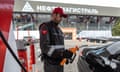 An employee holds a petrol pump nozzle at a Moscow fuel station.