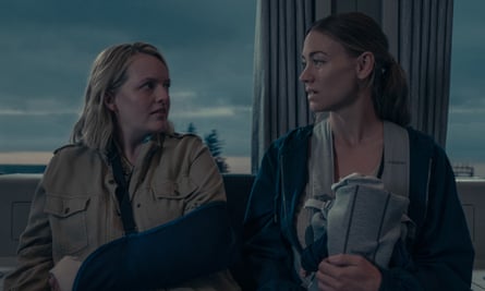 Two women on a train, one with a baby in a sling