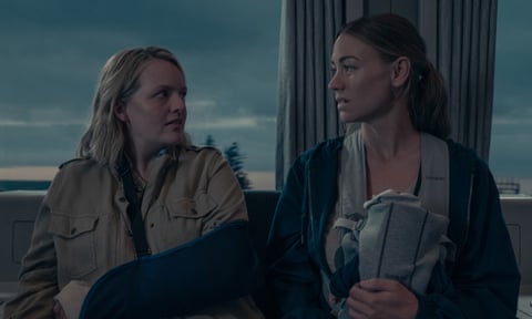 Two women on a train, one with a baby in a sling