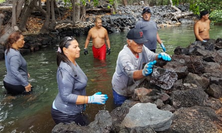 Ku’uleini Keakealani, front left, works with volunteers to repair a fish pond wall.