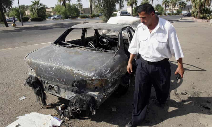 An Iraqi traffic policeman inspects a car destroyed by a Blackwater security detail in Baghdad, Iraq, on 25 September 2007.