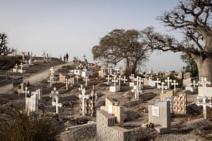 People walk through a mixed Catholic and Muslim cemetery