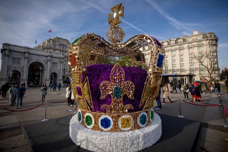 People walk by an art installation depicting the St Edward's crown in central London.