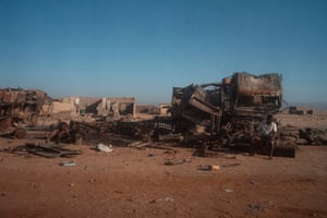 A man sits on wreckage from a suicide bomb attack