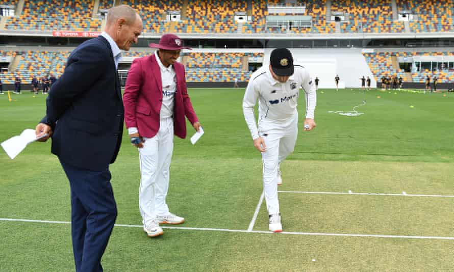 Queensland captain Usman Khawaja (second left) and his Western Australia counterpart Shaun Marsh eagerly check in on the outcome of the toss in their recent Sheffield Shield game.