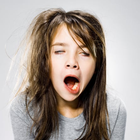 A girl with messy hair yawning in an exaggerated way