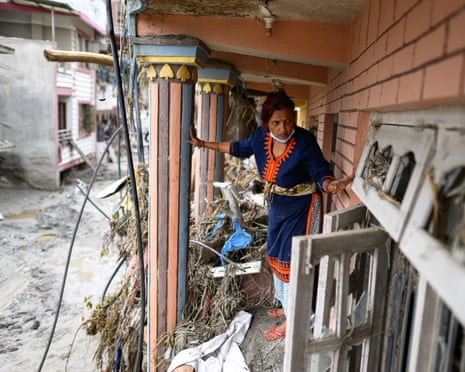A woman salvages her belongings at Devighat in Nepal's Nuwakot district