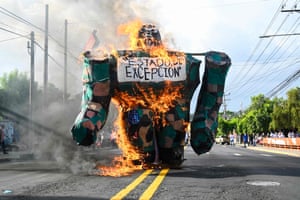 A burning gorilla model with a sign reading ‘state of emergency’ during a demonstration in San Salvador commemorating the 47th anniversary of the massacre of university students on 30 July 1975