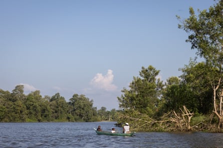 A woman and two children in a canoe on a wide river