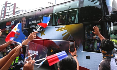 Boxing star and Filipino senator Manny Pacquiao waves to supporters as he files his candidacy for the national elections