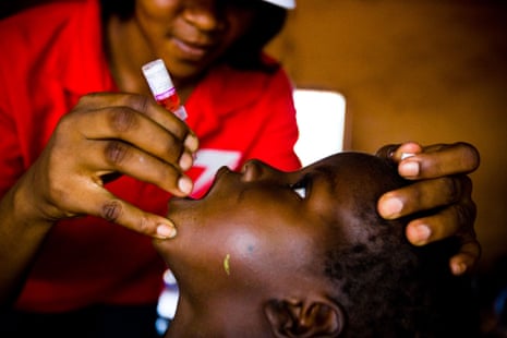 A health worker gives drops from an oral vaccine to a child