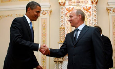 Barack Obama smiles and shakes hands with Vladimir Putin.