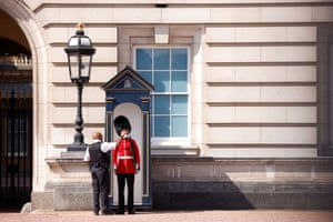A member of the Queen’s Guard receives water to drink outside Buckingham Palace