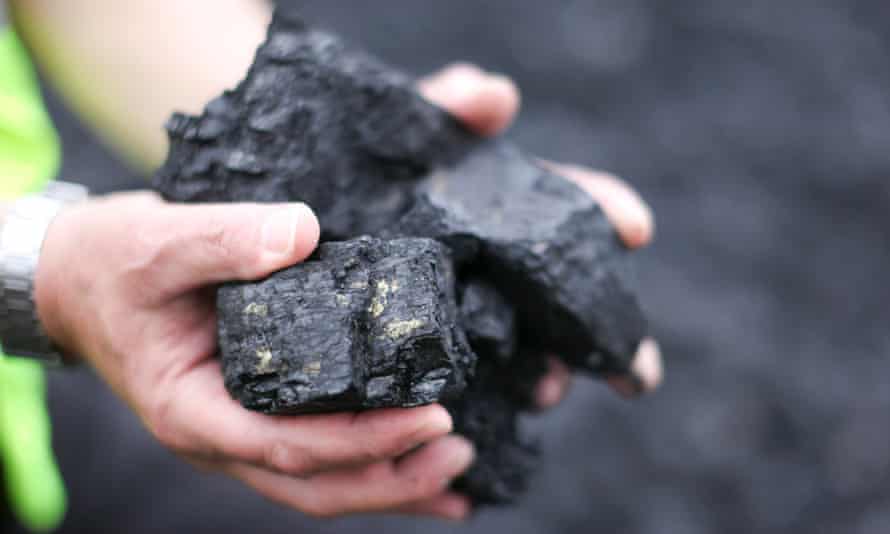A miner holds a handful of coal at the Lodge House surface coal mine in Ilkeston, Derbyshire.