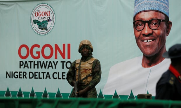 A soldier stands guard in front of a banner with a picture of Nigeria’s President Muhammadu Buhari in Gokana, Nigeria, during the launch of an exercise to clean up pollution in Ogoniland, in June 2016.