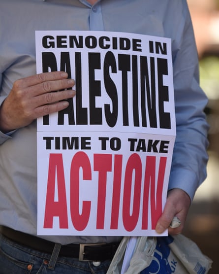A sign that says ‘Genocide in Palestine, time to take action’. The words ‘Palestine’ and ‘action’ are larger than the others