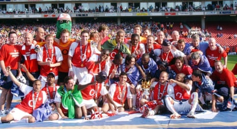 Arsenal players celebrate with the Barclaycard Premiership trophy after their match against Leicester City at Arsenal's Highbury Stadium May 15 2004.