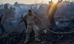 Army soldiers using water hoses try to extinguish forest fires close to the Kemerkoy thermal power plant in Oren, Turkey