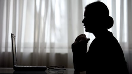 Silhouette of woman folding hands and looking at screen of laptop