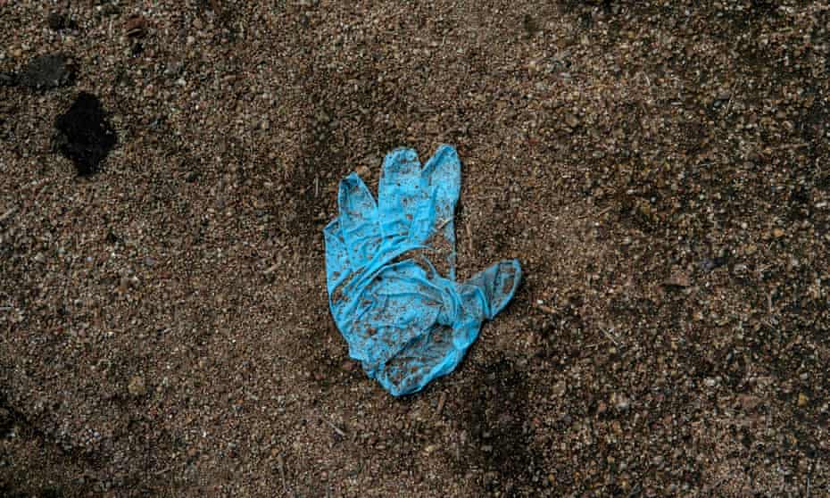 View of a surgical glove on the ground near new common graves in Tijuana, Mexico – now the murder capital of the world.