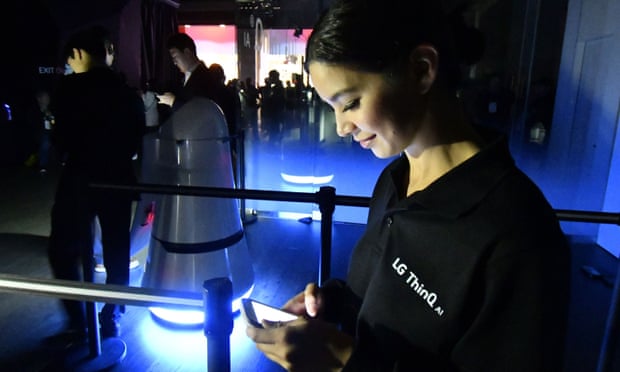 CES attendees use their cellphone lights to make there way out of the LG booth after a major blackout power outage.