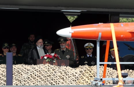 Part of a drone is seen passing in front of Iran’s president during the army day parade.