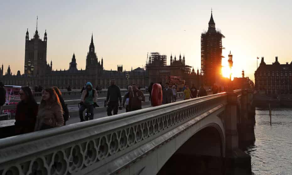 Pedestrians cross Westminster Bridge in London on the anniversary of the first UK lockdown
