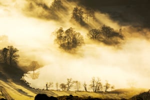 Looking down on to Loughrigg Tarn above valley mist, one of many clean, freshwater bodies in the Lake District national park, UK