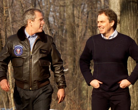 George W Bush and Tony Blair walk side by side in woods