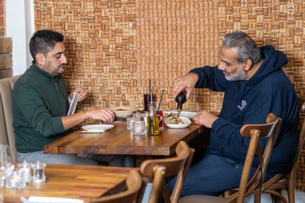 Two men facing each other across a restaurant table
