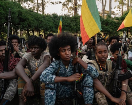 Young Fano fighters setting on ground holding flags