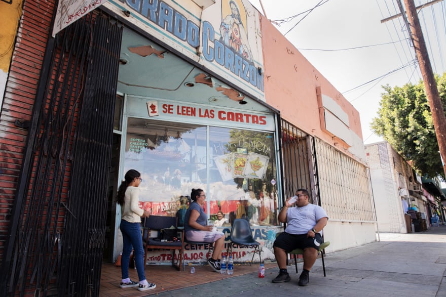 Azareth Jimenez est assise devant le magasin de sa mère sur Cesar E Chavez Avenue à Boyle Heights, Los Angeles.