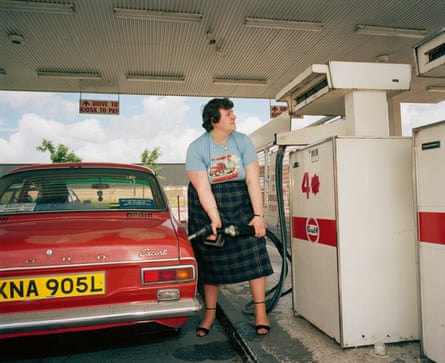 A woman filling up her car at a petrol station in 1986