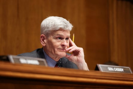 A man with his hand on his face, listening intently.