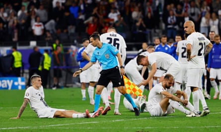Slovenia players slump to the turf after losing the shootout