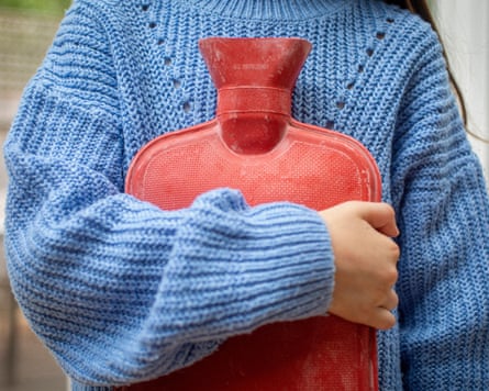 A little girl holding hot water bottle against her