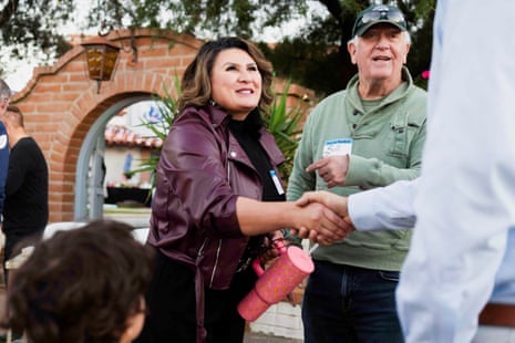 a woman shakes hands with a supporter