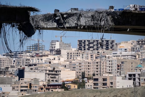 A closeup view of the destroyed bridge with the city seen in the background.