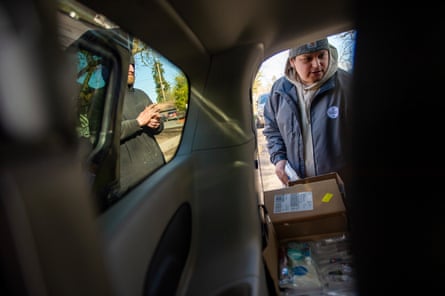 View from inside of a car looking out at two people with cardboard boxes.