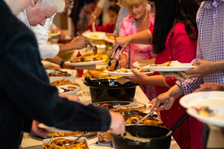 People fill their plates during a communal meal