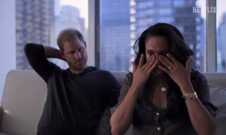 She sits sobbing and he is in the background