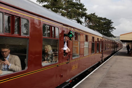 A man in an Irish hat for St Patricks Day onboard a steam train at the racecourse station.