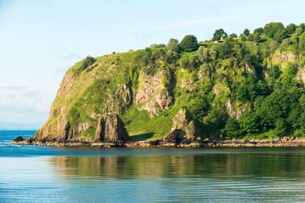 steep headland with trees, pillboxes, grass and rocks