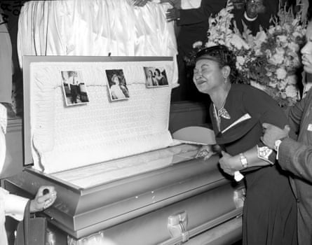 a woman crying at a open casket