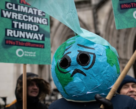 A papier-mâché globe with a sad face and a tear is held at an anti-Heathrow expansion protest in 2020