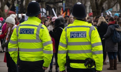 Two Met police officers with backs turned.
