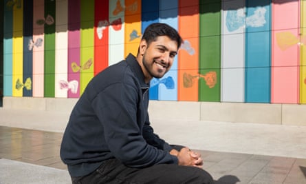 Sam Pordale, seated and smiling, on the University of Warwick campus