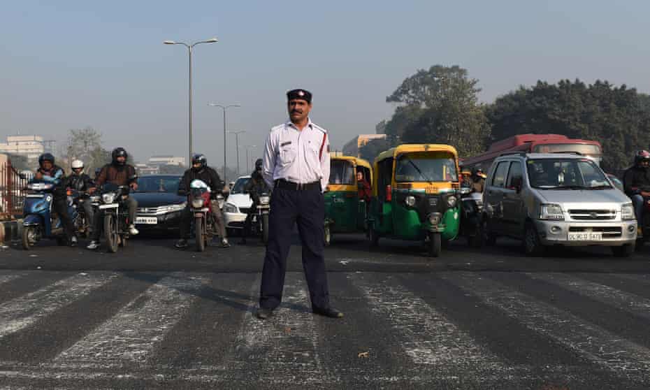 A traffic police officer at an intersection in New Delhi. Millions of Delhi drivers will have to find alternative ways to get to work from 1 January.