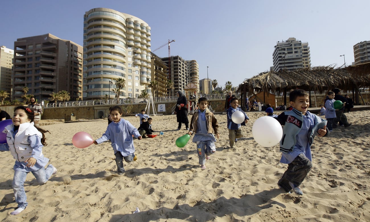 Lebanese school children run with the balloons on Beirut’s Ramlet al-Baida beach on January 20, 2011